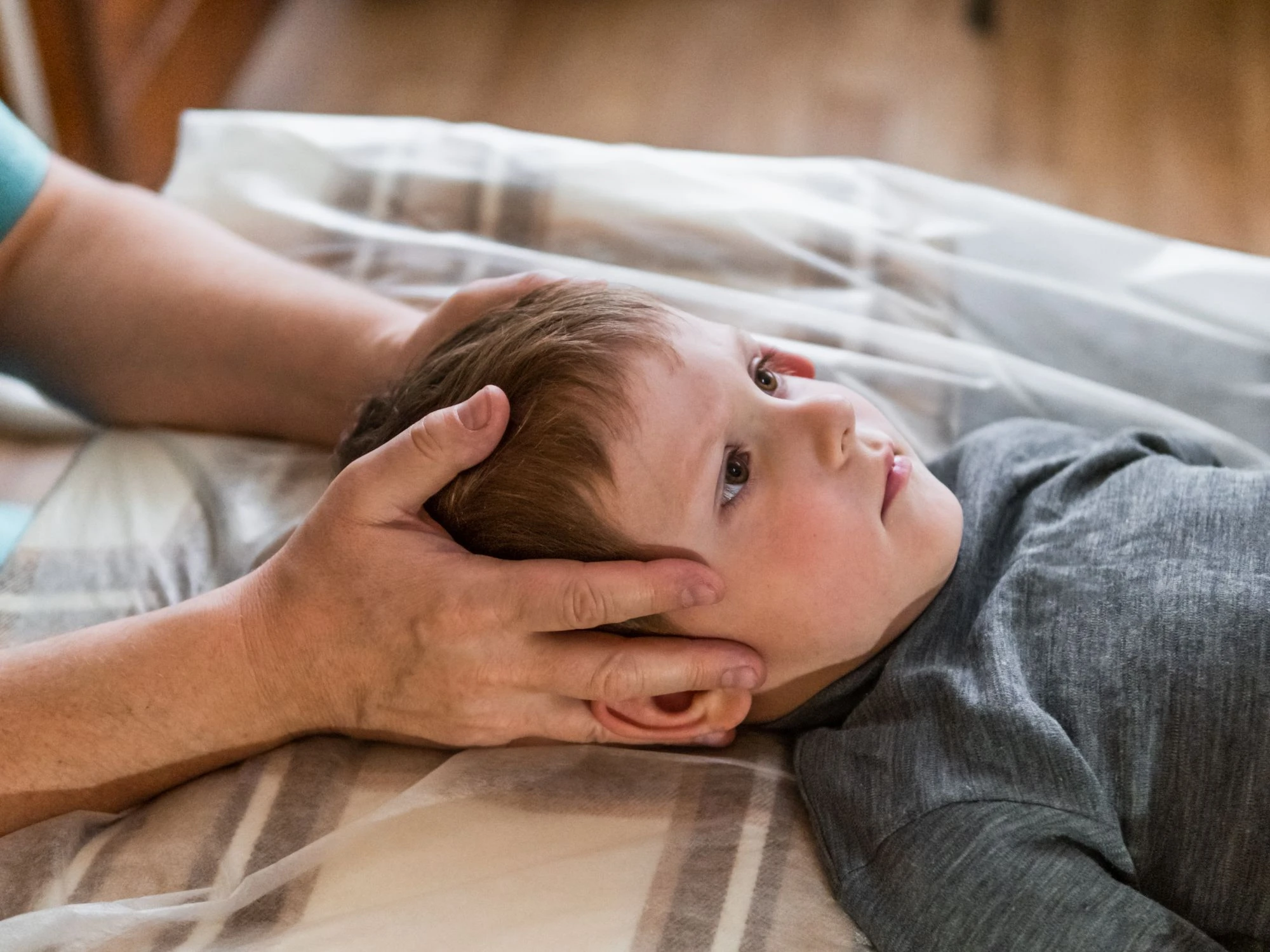 Osteopath giving gentle cranial treatment to a young child